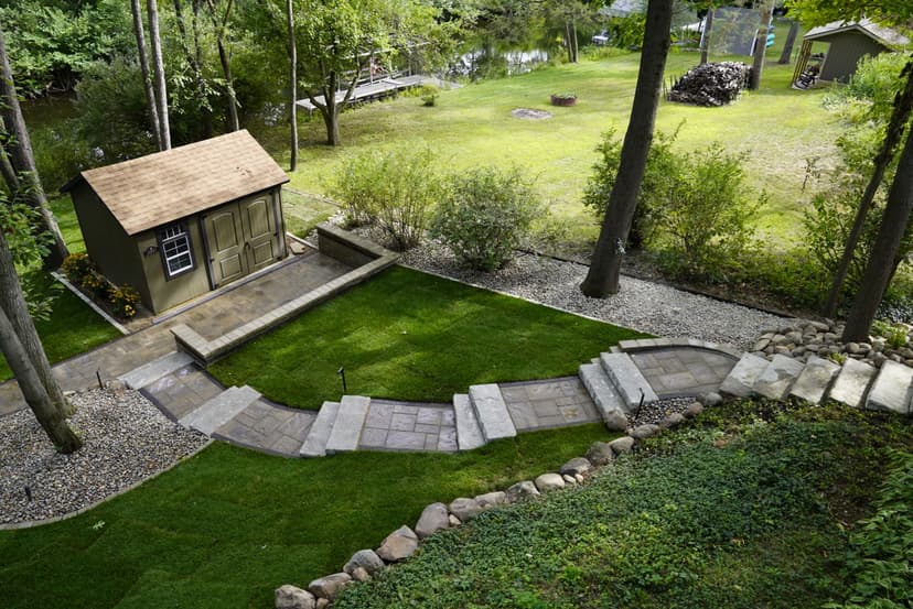 Aerial view of a landscaped garden with a stone path leading to a small shed.